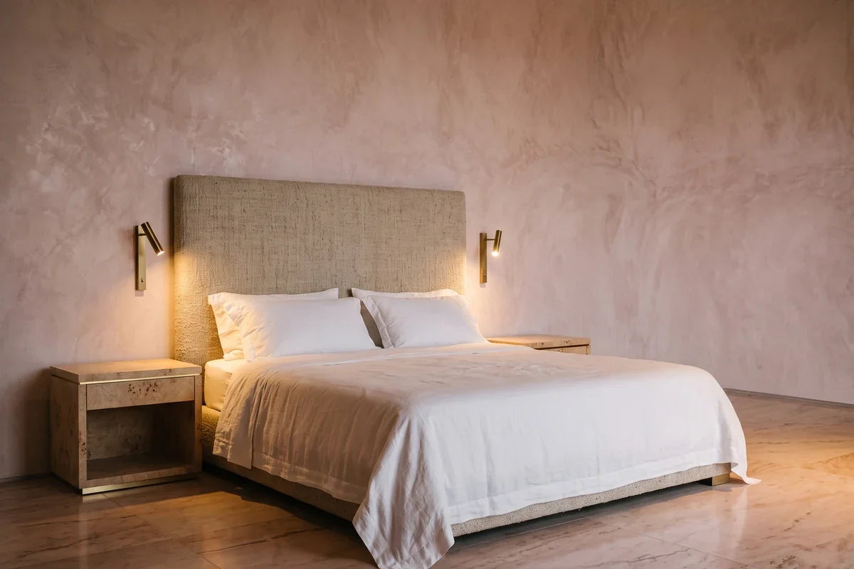 Éclairage de chambre : deux appliques liseuses de part et d'autre d'une tête de lit en lin épais.
