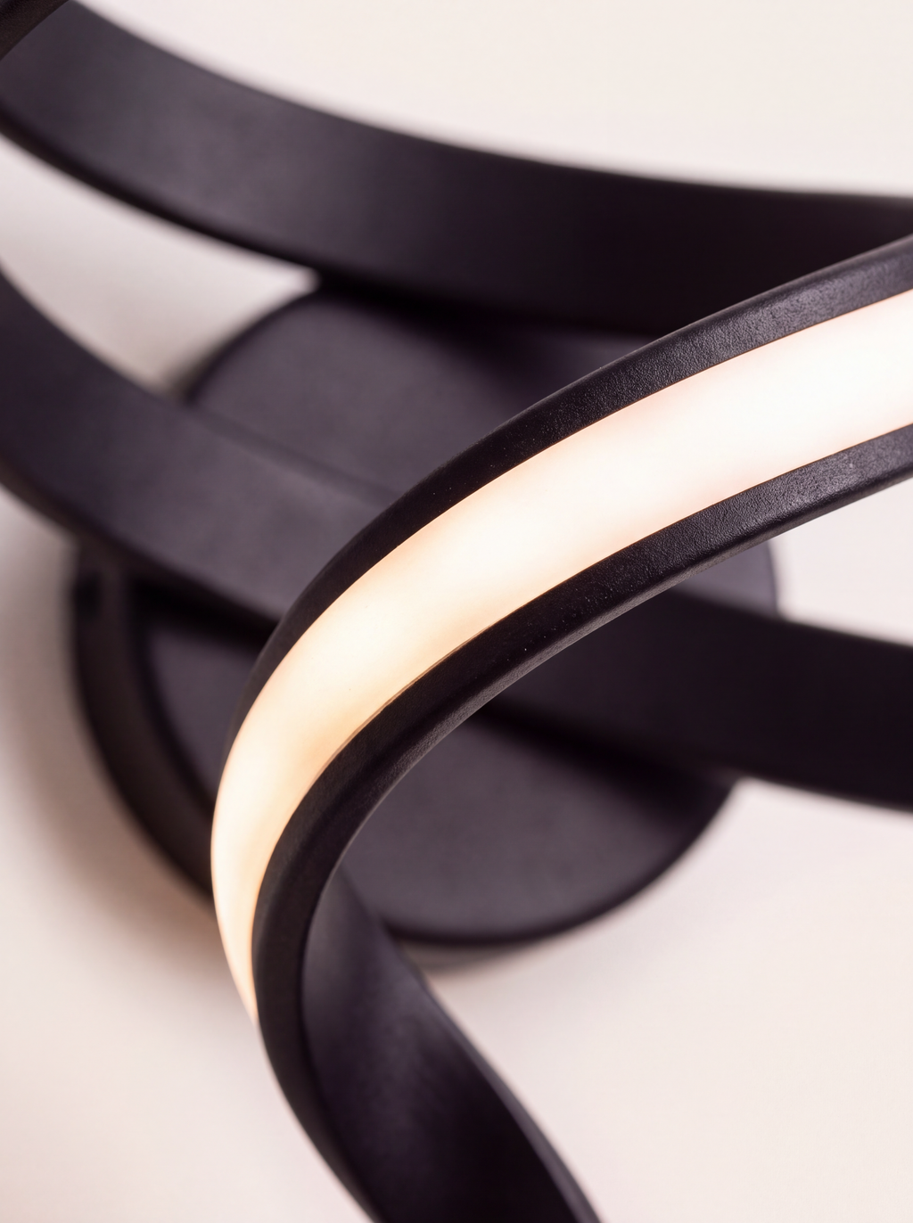 Détail du ruban de métal noir mat et de la bande de silicone translucide allumée de l'applique Blois