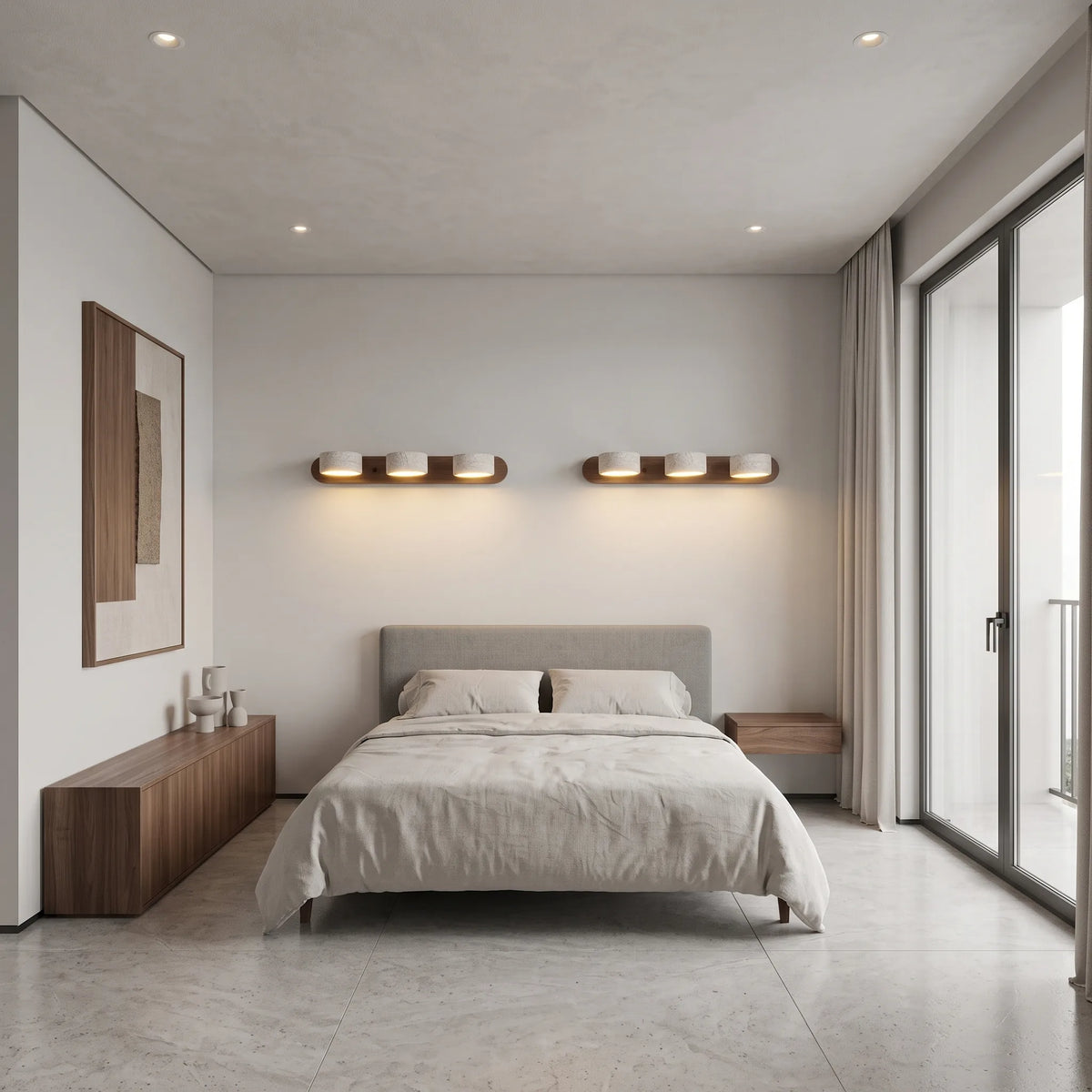 Applique murale 3 spots orientables Lumilarme au-dessus d'un lit, mur de travertin honé et tête de lit en daim caramel