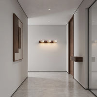 Applique murale 3 spots orientables Lumilarme, barre de noyer et cupules de travertin, dans un couloir au panneau mural sculpté