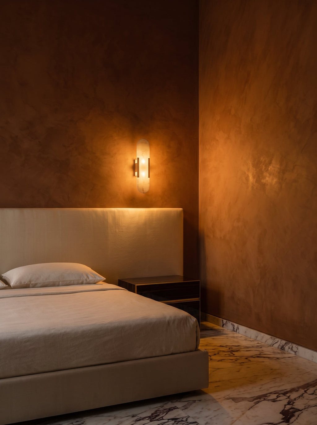 Applique murale plate Iéna dans une chambre au stuc terracotta, au-dessus d'une tête de lit ivoire