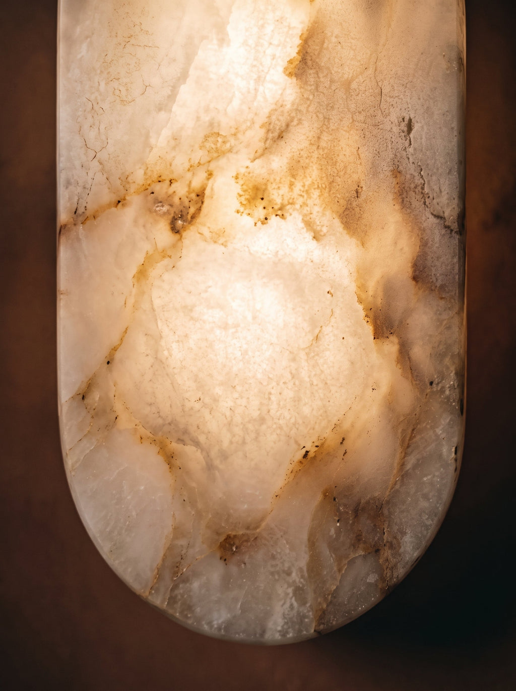 Détail du panneau translucide à l'aspect d'une pierre veinée de l'applique Iéna, allumée