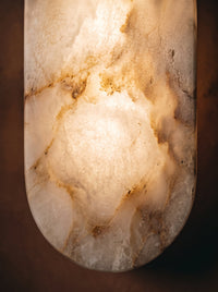 Détail du panneau translucide à l'aspect d'une pierre veinée de l'applique Lifatte, allumée