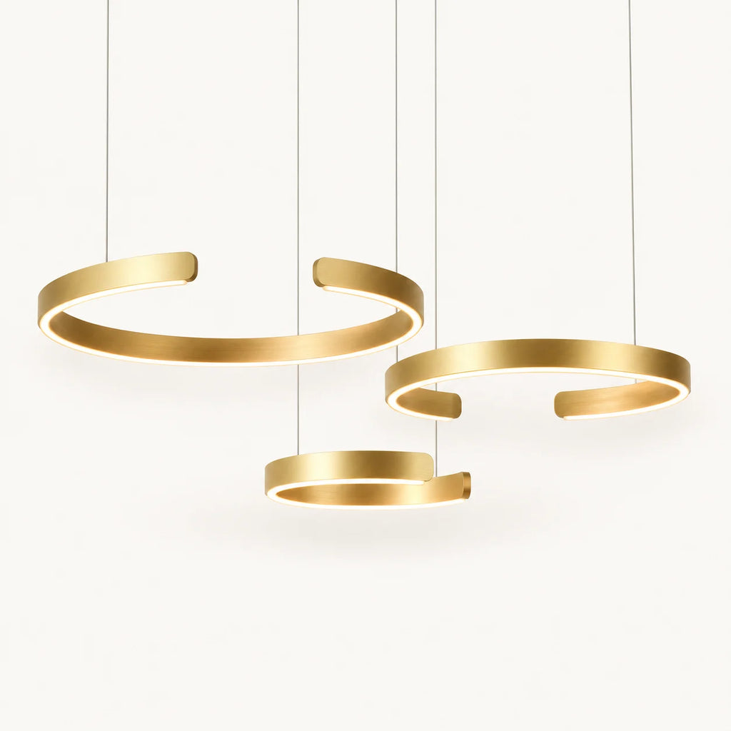 Suspension anneaux LED en aluminium doré brossé, anneaux allumés sur fond ivoire