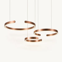 Suspension à anneaux en aluminium or rosé brossé, lumière chaude sur la face interne