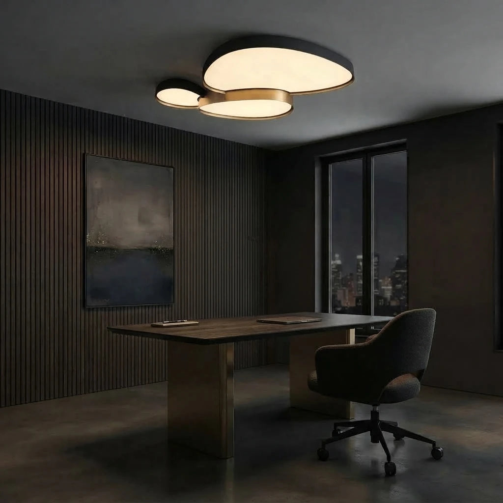 Plafonnier noir à trois galets au plafond d'un bureau, au-dessus d'une table de travail.