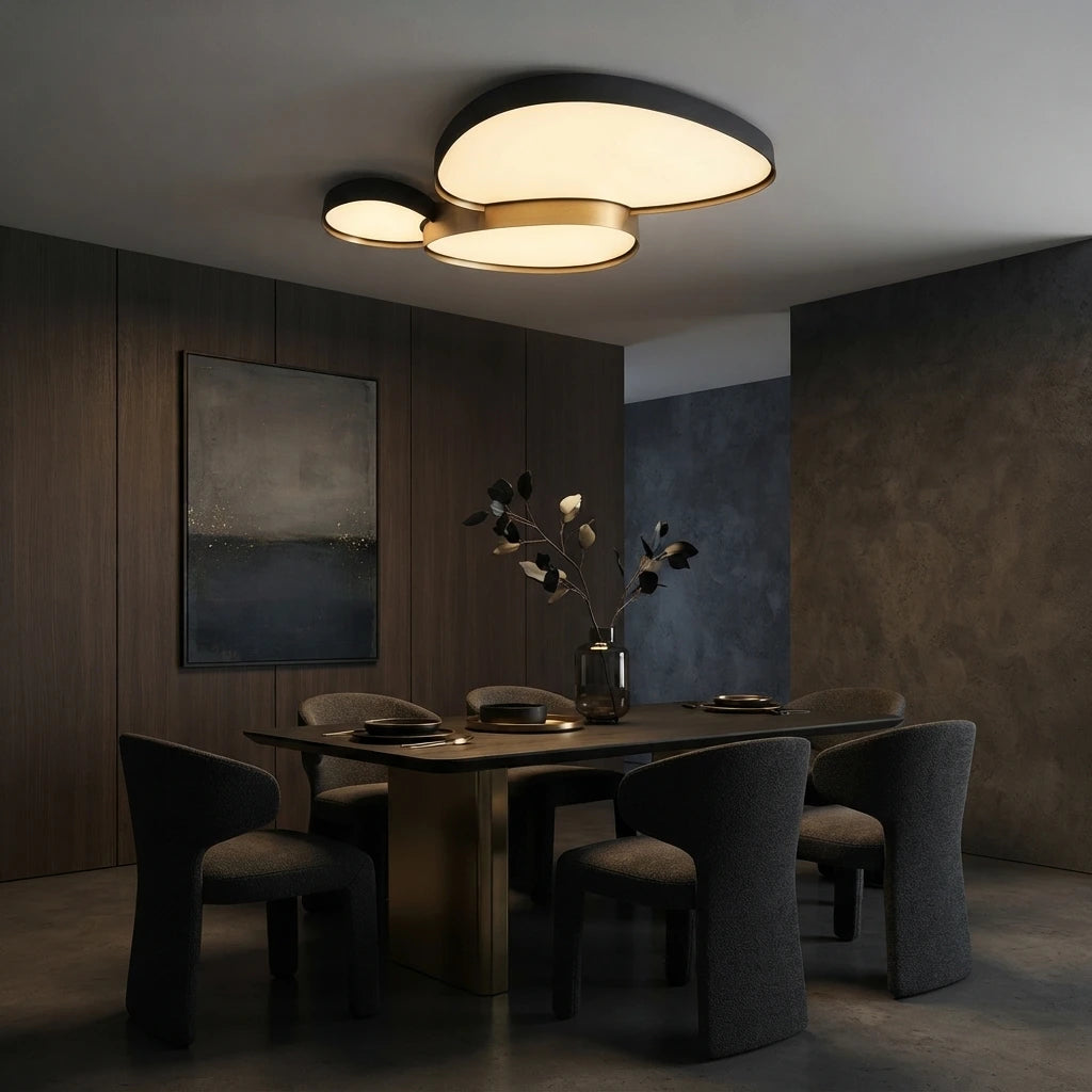 Plafonnier noir à trois galets au-dessus d'une table de salle à manger en bois sombre.