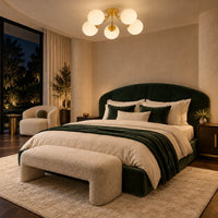 Plafonnier à cinq globes de verre dépoli allumé au-dessus d'un lit à tête de velours vert