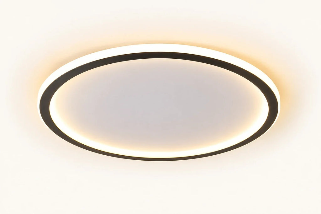Plafonnier extra plat LED Janssen, jonc d'aluminium noir cerclant un diffuseur de silicone, allumé