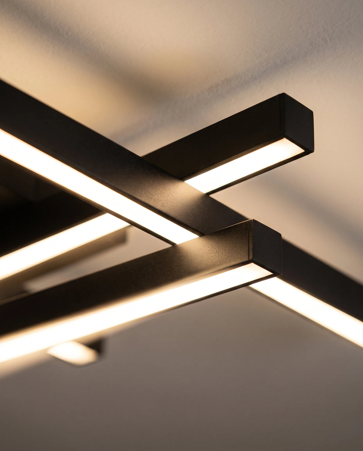 Détail du croisement de deux barres noires du plafonnier Sceaux et de leur ligne lumineuse continue