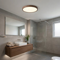 Plafonnier rond décor noyer au plafond d'une salle de bain, hors de la zone de douche