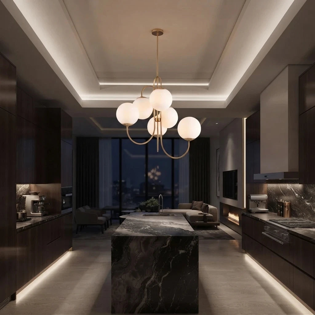 Le luminaire doré au-dessus d'un îlot de cuisine en pierre veinée