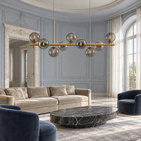 Globes de verre fumé sur barre doré satiné dans un salon aux boiseries bleu gris, en journée