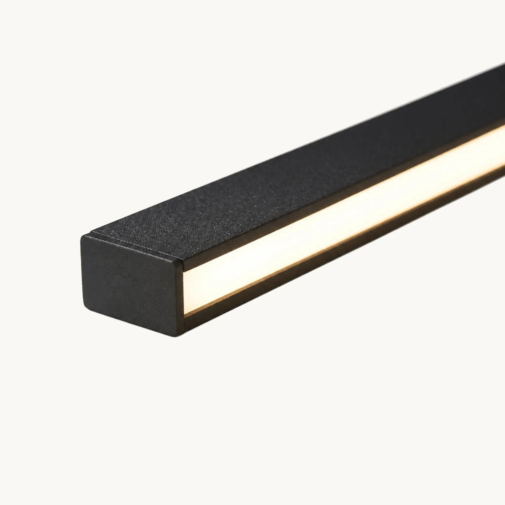 Macro d'une barre de métal noir à peinture texturée et de sa gorge LED allumée