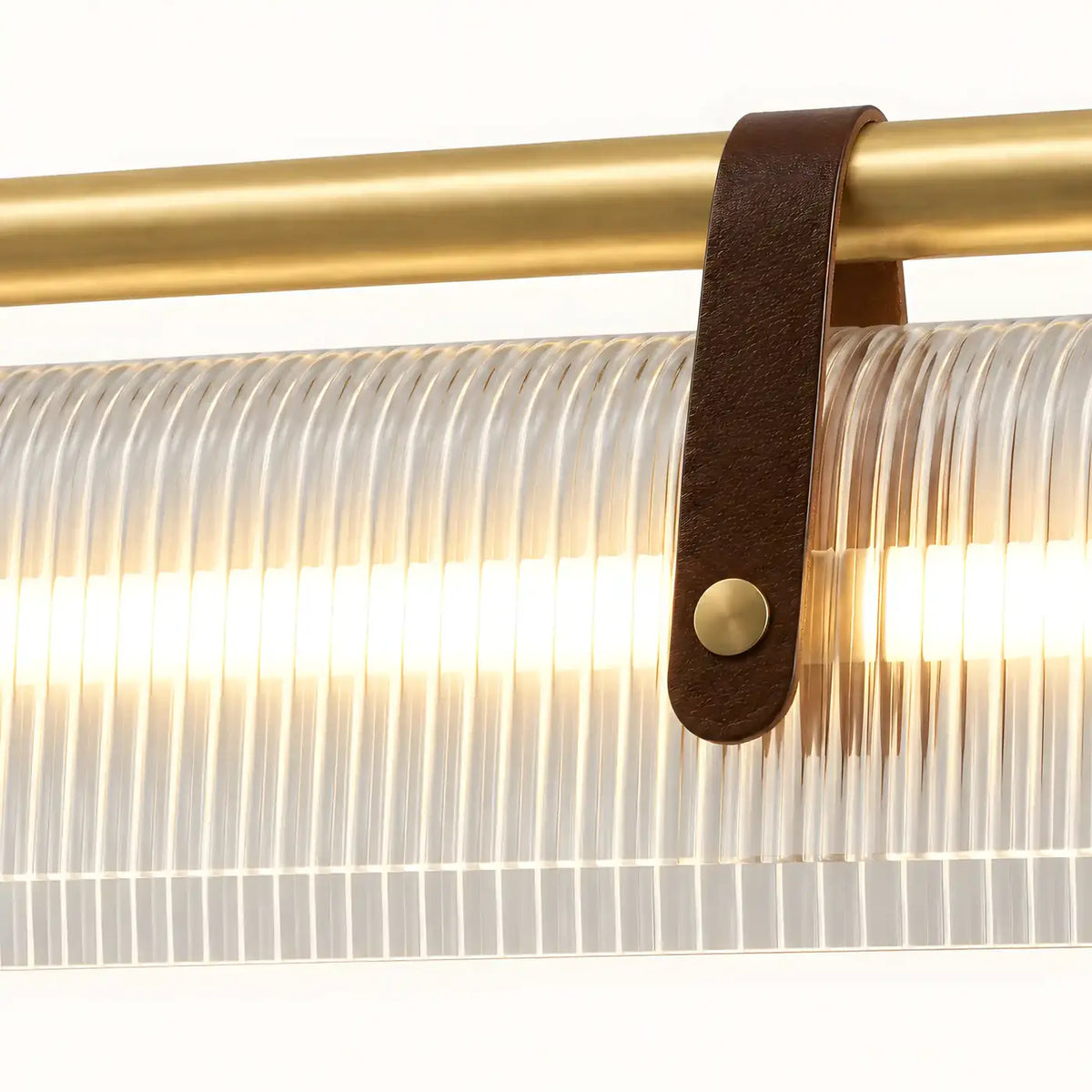Détail de la sangle façon cuir bouclée sur la traverse dorée satinée, devant les stries du diffuseur