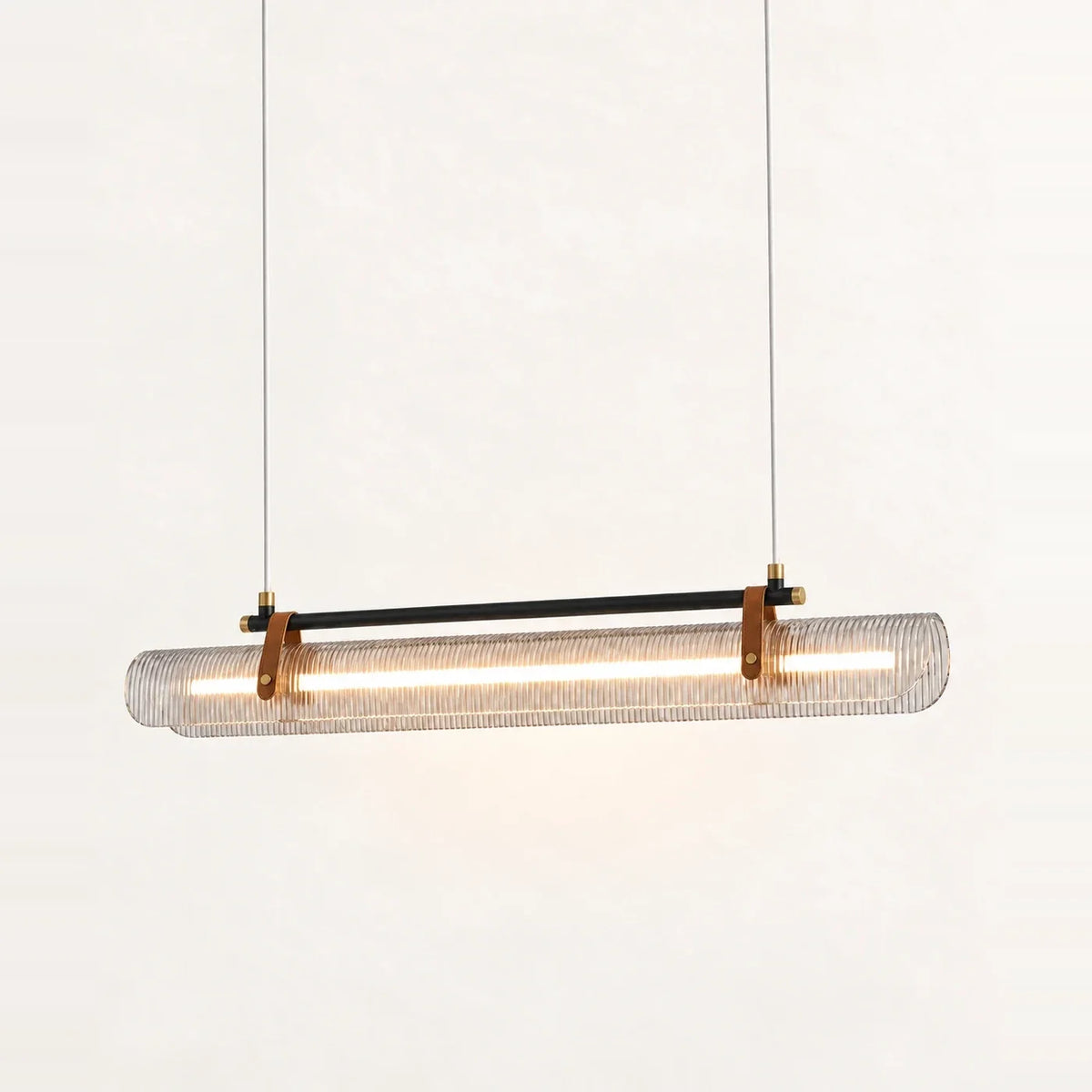 Suspension barre LED Ravel en finition noir mat, diffuseur strié tenu par deux sangles brunes façon cuir