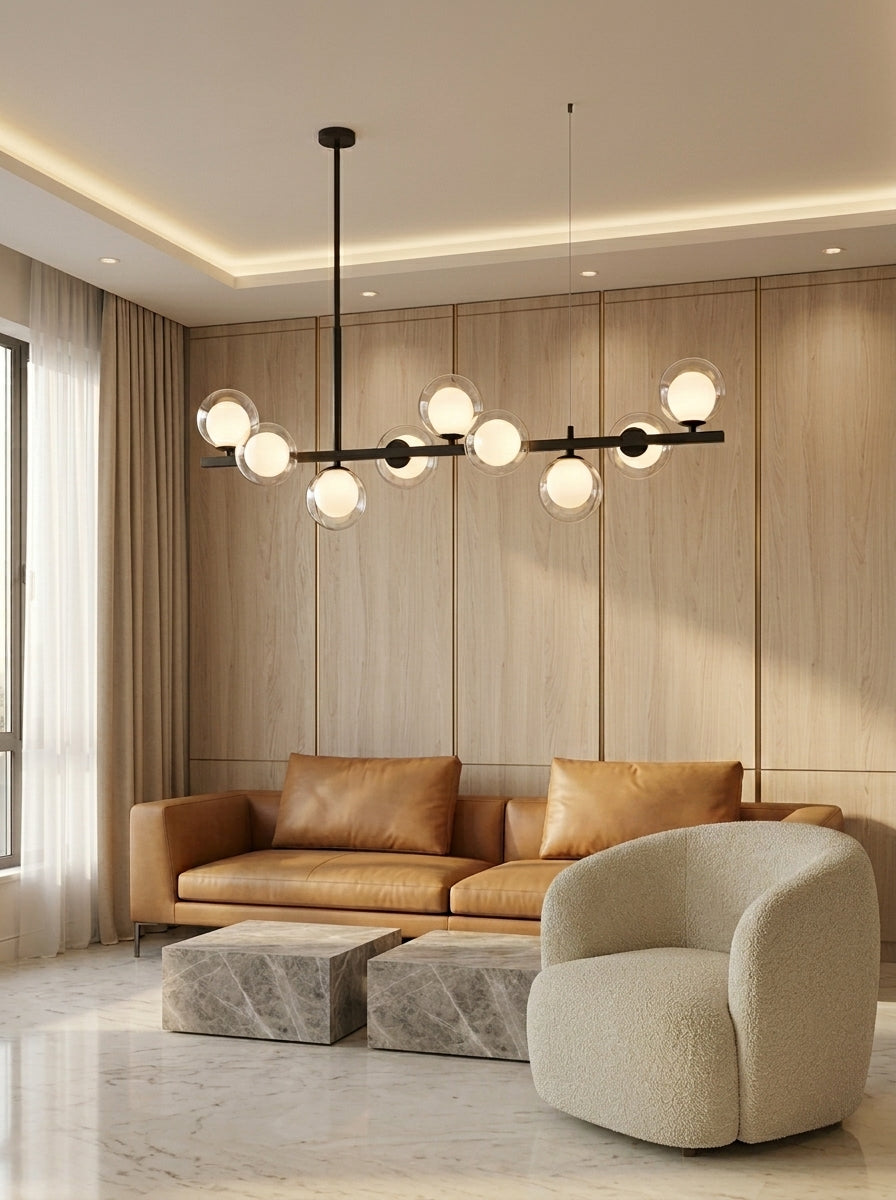 Barre noir charbon et globes doubles au-dessus d'un canapé de cuir camel, salon aux panneaux de bois blond